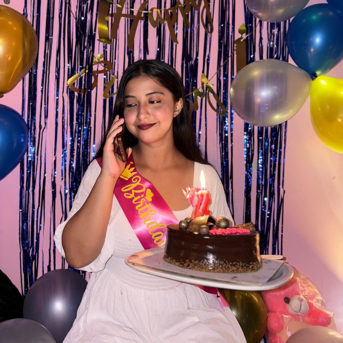 Amisha on the phone with cake in hand